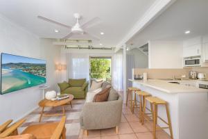 a kitchen and living room with a couch and a table at Riverside Retreat, Noosaville in Noosaville
