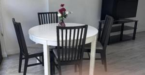 a white dining room table with chairs and a vase with flowers at Olympicpark 12 Free Parking in Sydney +3 photos