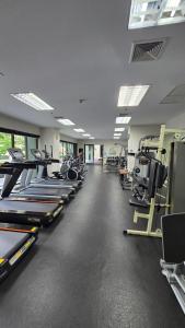 a gym with a row of treadms and machines at ELiTE 61 THONGLOR in Sathani Khlong Tan