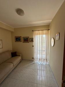 a living room with a couch and a window at Casa Le Araucarie in Mascali