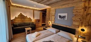 a bedroom with a large bed and a couch at Garni Hotel Residence Diamant in San Vigilio Di Marebbe
