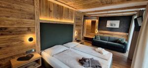 a bedroom with a bed and a couch in it at Garni Hotel Residence Diamant in San Vigilio Di Marebbe