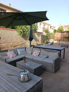 eine Terrasse mit Sofa und Tisch mit Sonnenschirm in der Unterkunft Studio Chill in Canet-en-Roussillon