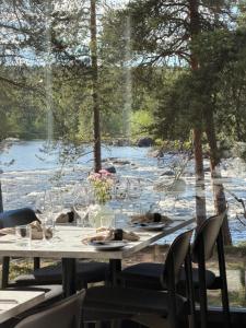 a table with wine glasses and a view of a river at Wilderness Hotel Juutua in Inari