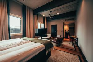 a bedroom with a bed and a desk and a chair at Clarion Hotel Mestari in Helsinki