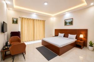 a bedroom with a bed and a desk and a chair at Hotel Meridian Sector 132, Near Max Hospital in Noida