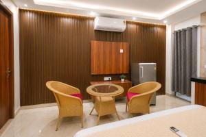 a room with a table and chairs and a refrigerator at Hotel Meridian Sector 132, Near Max Hospital in Noida +23 photos