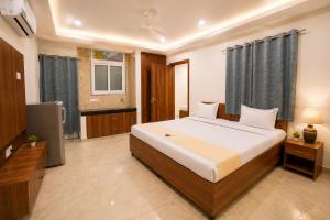 a bedroom with a large bed and a television at Hotel Meridian Sector 132, Near Max Hospital in Noida