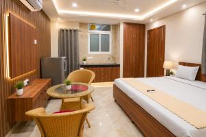a bedroom with a bed and a table and chairs at Hotel Meridian Sector 132, Near Max Hospital in Noida
