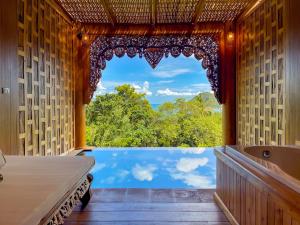 a bathroom with a view of a tub and a window at Santhiya Koh Phangan Resort & Spa - Up to THB 2,000 Resort Credit per Night in Thong Nai Pan Noi