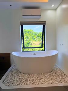 a bath tub in a bathroom with a window at Baram Villas Phong Nha in Hà Lời +29 photos