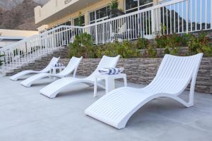 a row of white chairs sitting in front of a building at paradise resort and spa in Hatta