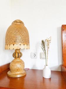 a table with a lamp and a vase on it at Eleen Bungalow in Tetebatu