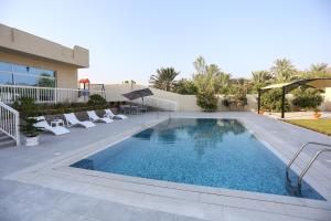a swimming pool in front of a building at paradise resort and spa in Hatta