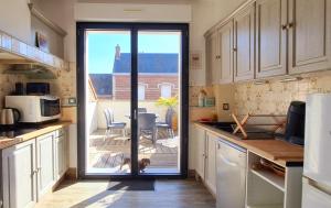 a kitchen with a door leading to a patio at LES FRUITS DE MER, plage et centre à pied, lits faits, parking gratuit, animal bienvenu in Berck-sur-Mer