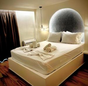 a bedroom with a bed with towels on it at LefkoParga Luxury Suites in Parga