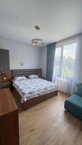 a bedroom with a bed and a couch in it at Apollo Cottages Kaprovani in Urekis Sadguri