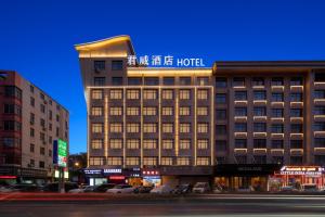 a hotel building with a sign on top of it at 义乌君威酒店 in Yiwu