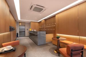 a hotel lobby with a reception desk and tables and chairs at 义乌君威酒店 in Yiwu
