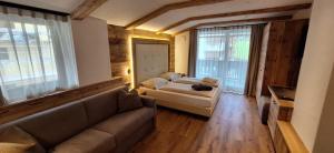 a living room with a couch and a bed at Garni Hotel Residence Diamant in San Vigilio Di Marebbe