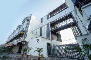 a white building with palm trees in front of it at Surendra Landmark By Spree Hotels Bhopal in Bhopal +3 photos