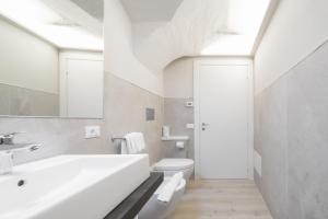 a white bathroom with a sink and a toilet at Hotel Baia D'Oro - Adults Only in Gargnano +64 photos