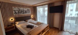 a bedroom with a bed with a backpack on it at Garni Hotel Residence Diamant in San Vigilio Di Marebbe