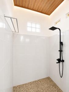a shower in a white room with a skylight at Eleen Bungalow in Tetebatu +31 photos