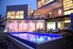 a swimming pool in front of a house at Villa CaMa in Kapetan stan