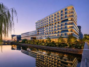 a large office building next to a river at Radisson Hotel, Beijing DaXing Airport in Beijing
