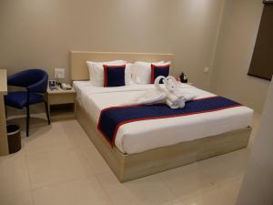a bedroom with a bed with a stuffed animal on it at Surendra Landmark By Spree Hotels Bhopal in Bhopal