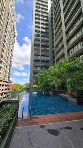 a swimming pool in the middle of two tall buildings at ELiTE 61 THONGLOR in Sathani Khlong Tan