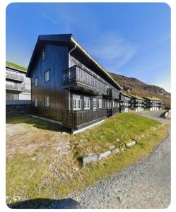 a large wooden building with a gambrel roof at Apartment Røldalsfjellet in Håra