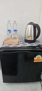 a black appliance with a tea kettle and two glass bottles at Papa house in Pak Kret