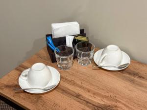 two plates and glasses on a wooden table at Da Vinci Hotel in Almaty