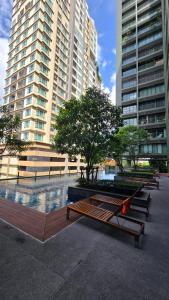 a row of benches in front of tall buildings at ELiTE 61 THONGLOR in Sathani Khlong Tan