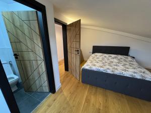 a bedroom with a bed and a sliding door at Casa Urbano Mall- Floresti in Floreşti
