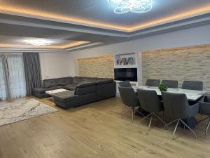 a living room with a couch and a table and chairs at Casa Urbano Mall- Floresti in Floreşti