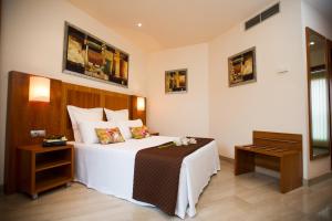 a bedroom with a large white bed and a table at Leflet Valme in Dos Hermanas