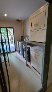a laundry room with a row of washers and dryers at ELiTE 61 THONGLOR in Sathani Khlong Tan