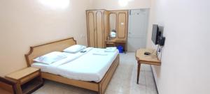 a small bedroom with a bed and a television at Hotel shri annalakshmi lodge in Theni +2 photos