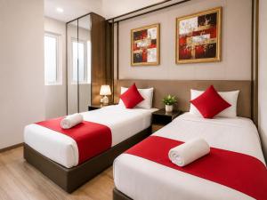 two beds in a hotel room with red and white pillows at Panoramic Sea view 2BR Duplex High Floor George Town 203A Maritime Suite in George Town