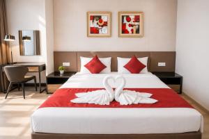 two white swans sitting on a bed in a hotel room at Panoramic Sea view 2BR Duplex High Floor George Town 203A Maritime Suite in George Town