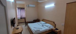 a small room with a bed and a mirror at Hotel shri annalakshmi lodge in Theni