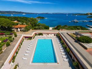 an overhead view of a swimming pool with lounge chairs and the water at Baja Sardinia Sea View And Pool B in Baja Sardinia +6 photos