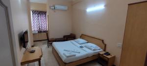 a small bedroom with a bed and a window at Hotel shri annalakshmi lodge in Theni
