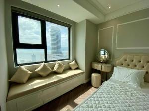 a window seat in a bedroom with a view of a city at Amanda Apartment Quy Nhon in Quy Nhon