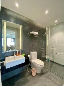 a bathroom with a toilet and a sink and a shower at Amanda Apartment Quy Nhon in Quy Nhon