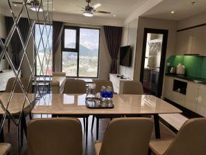 a dining room with a table and chairs and a kitchen at Amanda Apartment Quy Nhon in Quy Nhon