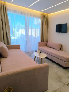 a living room with a couch and a table at Calm Luxury Villas in Limenaria